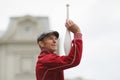 A man in a cap juggles with clubs on the street