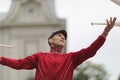 A man in a cap juggles with clubs on the street