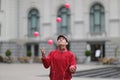 A man in a cap juggles with pink balls on a stree