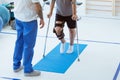Man after car accident in an orthosis and on crutches learning to walk in the clinic Royalty Free Stock Photo