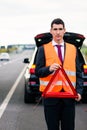 Man with car breakdown erecting warning triangle Royalty Free Stock Photo