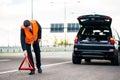 Man with car breakdown erecting warning triangle Royalty Free Stock Photo