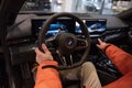 man in car driving BMW i5 eDrive40, digital panel, Interior, cockpit modern EV, male hands on steering wheel, driving safety,