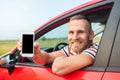 The driver shows a smartphone with a blank screen. Royalty Free Stock Photo