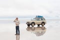 Man and car on lake Salar de Uyuni Royalty Free Stock Photo