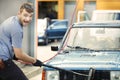 Oldtimer car enthusiast washing his small car by water Royalty Free Stock Photo