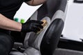 Man car wash worker cleaning leather boat seat with brush