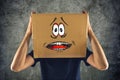 Man with cardboard box on his head and terrified look skethed