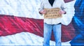 Man with cardboard sign, Out of Work military Veteran, with American Flag,