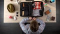 Man carefully packing suitcase, preparing for business travel, official journey