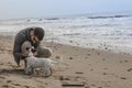 Man caressing his dog while playing in the beach Royalty Free Stock Photo