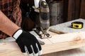 A man carpenter cuts a wooden beam using an electric jigsaw, male hands with an electric jigsaw closeup. Work with wood Royalty Free Stock Photo