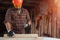 A man carpenter hammer a nail into a tree, male hands with a hammer close-up. Woodwork Royalty Free Stock Photo