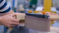 Man carpenter using belt sander machine, polishing wood product: close up