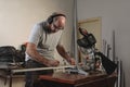 Man in a carpentry shop measuring white aluminum profile with tape measure. Profile to make a mosquito net