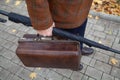 Man with carpetbag in jacket stands in alley of autumn park Royalty Free Stock Photo