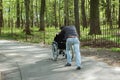 Man carries a disabled person in a wheelchair