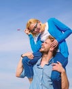 Man carries girlfriend on shoulders, sky background. Woman enjoy perfect romantic date. Couple happy date having fun