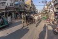 man carries heavy cargo with his wooden cart in old Delhi