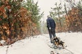 Man carries wood on a sled in the winter snowy forest