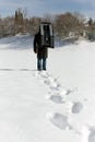 Man carry a sledge in the deep snow, footprints in the front Royalty Free Stock Photo