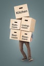 Man carrying a big stack of moving boxes labeled with different rooms Royalty Free Stock Photo