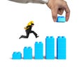 Man carrying dollar sign running bar graph block hand building