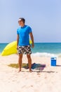 A man carrying a green umbrella and standing on the beach looking on the beach Royalty Free Stock Photo