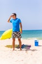 A man carrying a green umbrella and standing on the beach looking on the beach Royalty Free Stock Photo