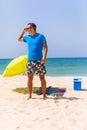 A man carrying a green umbrella and standing on the beach looking on the beach Royalty Free Stock Photo