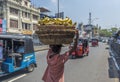 Man carrying heavy basket with bananas on his head