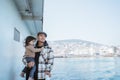 man carrying his daughter leaning against the railing of the ferryboat