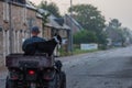 Man carrying his dog on a quad