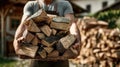 Man carrying a large stack of chopped firewood for heating outdoors Royalty Free Stock Photo