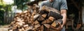 Man carrying a large stack of chopped firewood for heating outdoors Royalty Free Stock Photo