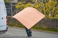 Man Carrying Large Wooden Sheets