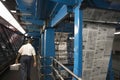 Man Carrying Newspaper Stack In Factory