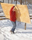 Man carrying a sheet of plywood