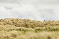 Man carrying a spotting scope on his shoulder walking along the Royalty Free Stock Photo