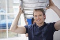 Man Carrying Stepladder With Woman Helping In Unrenovated House