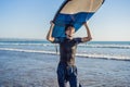 Man carrying surfboard over his head. Close up of handsome guy with surfboard on head at beach. Portrait of man carrying Royalty Free Stock Photo