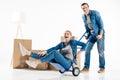 Man carrying woman on hand cart fooling around Royalty Free Stock Photo