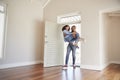 Man Carrying Woman Over Threshold Of Doorway In New Home