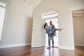 Man Carrying Woman Over Threshold Of Doorway In New Home