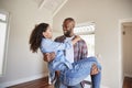 Man Carrying Woman Over Threshold Of Doorway In New Home