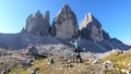 Man carrying woman piggyback with the close up view on the Tre Cime di Lavaredo (Drei Zinnen) in Italian Dolomites. Royalty Free Stock Photo