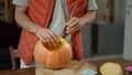 A man carves a pumpkin neatly