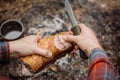 Man carving grilled rabbit meat in forest camp. Top view.