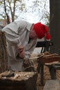 Man carving a wooden spoon historic garb