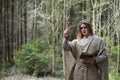 A man in a cassock spends a ritual in a dark forest